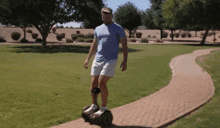 a man is riding a self balancing scooter down a brick path