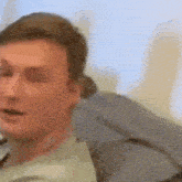 a man is sitting in a chair with his eyes closed and looking at the camera .
