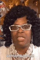 a woman wearing glasses and a necklace is making a face .
