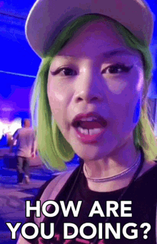 a woman with green hair is wearing a hat and asking how are you doing