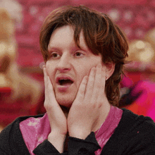a man with his hands on his face and his mouth open