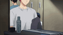 a bottle of aksy deodorant sits on a table next to a man