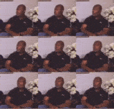 a man wearing a black puma shirt sits on a couch in front of flowers