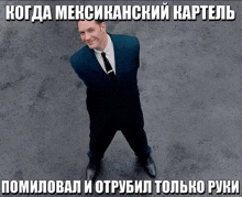 a man in a suit and tie stands in front of a sign that says " когда мексиканский картель "