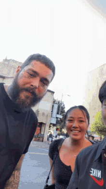 a man with a beard is posing for a photo with a woman wearing a nike shirt