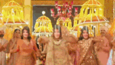 a group of people are dancing together in a room with a chandelier .