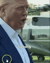 a man in a suit says " so long " in front of a helicopter