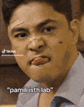 a man with a bandage on his nose is sticking his tongue out and says " pamili ish lab "