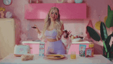 a woman in a pink kitchen holds a piece of chocolate and a jar of jam