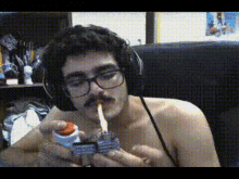 a man without a shirt is lighting a cigarette with a lighter