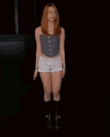 a woman in shorts and knee high socks is dancing in the dark .