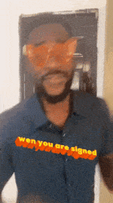 a man wearing sunglasses says " wen you are signed " on his shirt