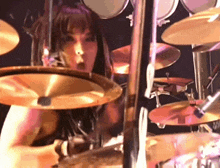 a woman playing a drum set with a cymbal that says ' a ' on it