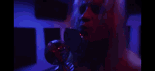 a woman is making a funny face in a blue room .