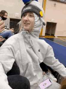 a girl wearing a hat that says cougars is sitting in a gym