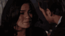 a man and a woman are standing next to each other and looking at each other .