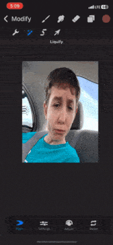 a man in a blue shirt is sitting in the back seat of a car with the time 5:09