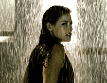 a woman is standing in the rain with her hair covered in water