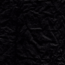 a crumpled piece of black paper with a purple circle in the middle
