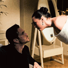 a man looks up at a woman in a white dress