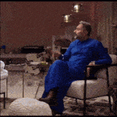 a man in a blue robe sits in a chair in front of a sign that says chapter2