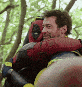 a man in a superhero costume is hugging another man