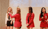 a group of women in red jackets are standing next to each other .