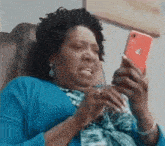 a woman is sitting in a chair looking at a cell phone .