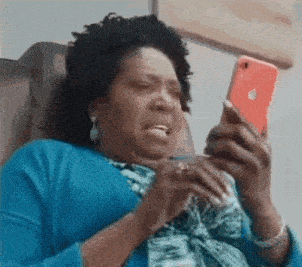 a woman is sitting in a chair looking at a cell phone .