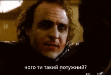 the joker from the movie the dark knight is talking to another man in another language .