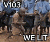 a man is kneeling down in front of a group of people with the words v103 we lit on the bottom