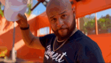 a bald man with a beard is wearing a connect t-shirt