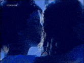 a man and a woman are hugging each other in a dark room with a rtl logo in the background