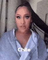 a woman with long hair and a ponytail is wearing a robe and earrings .