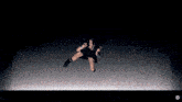 a woman in a black dress is singing into a microphone in a dark room