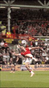 a soccer player jumps in the air to head a soccer ball