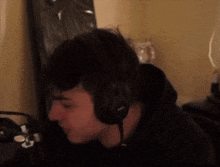 a man wearing headphones is sitting in front of a microphone .