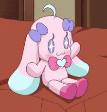 a stuffed animal with a heart on its chest is sitting on a couch