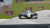 a race car is going around a curve with a honda sign behind it