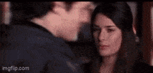 a man is kissing a woman on the forehead in a close up of a movie scene .