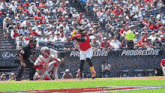 a baseball player swings his bat in front of a progressive banner