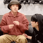 two young men are sitting next to each other on a couch .