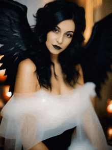 a woman with black wings is wearing a white off the shoulder dress