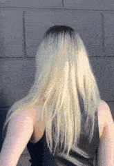a woman with blonde hair is wearing a black leather top