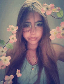 a girl with pink flowers in her hair and a star necklace