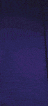 a person is standing in a dark room with a purple light behind them .
