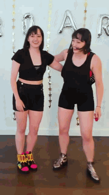 a couple of girls standing next to each other with balloons that say ' a ' on it
