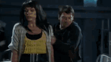 a woman is standing next to a man in a dark room .