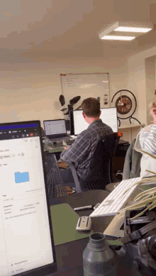 a man sits at a desk in front of a computer screen that says ' microsoft ' on it