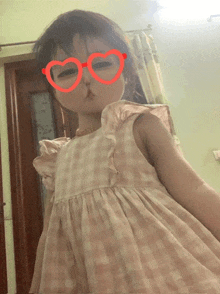 a little girl wearing heart shaped glasses makes a face